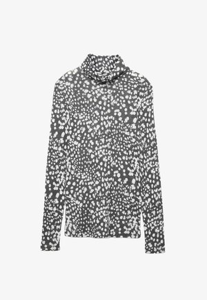 Top de cuello alto de mangas largas en tela gris con un patrón abstracto de puntos blancos. Presenta un ajuste relajado y una textura suave.
