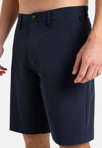 Marineblå shorts laget av lettvektig stoff, med frontknapp, sidelommer og rett snitt med stikkede kanter.