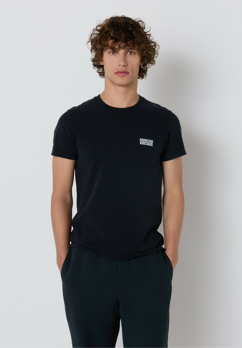 Čierne bavlnené tričko s okrúhlym výstrihom a krátkymi rukávmi, s malým bielym logom "American Vintage" na ľavom prsníku.