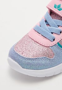Sjajni tenisice s dizajnom od pink i ljubičastog glittera, plavim vezicama i bijelim đonom. Podešavajući remen s akcentom u teal boji.