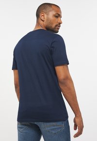 Navy blue cotton t-shirt with short sleeves and a crew neck, featuring a smooth texture and a relaxed fit. Designed for casual wear.