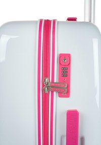 Maleta blanca con cremallera y acentos rosas, que cuenta con un candado de combinación y dos tiradores de cremallera. Textura suave y forma redondeada.