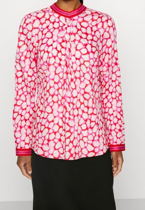 Camicia a maniche lunghe di colore rosa con un motivo astratto di forme bianche irregolari, dotata di un colletto e polsi solidi rosa con accenti rigati.