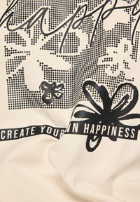 Cremfarbener Stoff mit schwarzem grafischem Text und floralen Designs, verziert mit Punkten und einem Ripsband, das "ERSTELLE DEIN EIGENES GLÜCK" sagt.