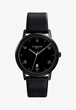 Zwarte leren bandhorloge met een ronde zwarte wijzerplaat, witte uur- en minutenwijzers, rode accenten en een datumaanduiding op 6 uur.