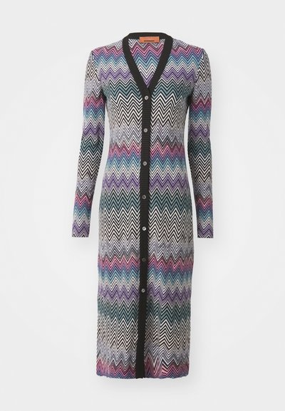 Cardigan longo com um padrão em zigzag nas cores preta, branca, roxa, azul e rosa. Tecido tricotado com decote em V e fecho por botões.