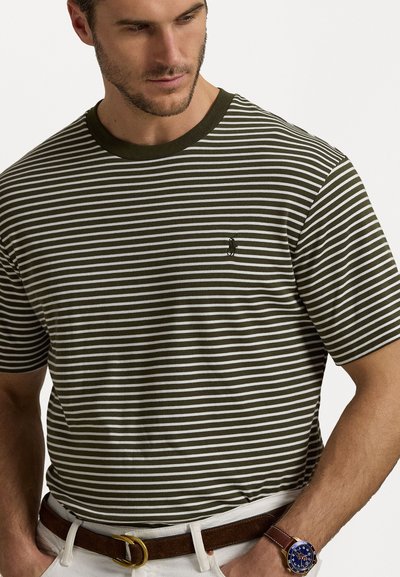 Olive green and white striped t-shirt with crew neck, short sleeves, and a small black logo on the chest. Paired with white pants and a brown belt.