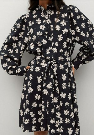 Ciemnoniebieska sukienka w biały kwiatowy wzór, z kołnierzykiem, długimi bufkowatymi rękawami i wiązanym paskiem w talii. Tkanina o fakturze.