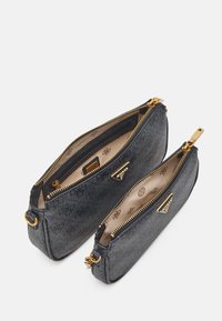 Dwa otwarte czarne, teksturowane skórzane etui z zamkiem błyskawicznym, z złotymi akcentami i beżowym wzorzystym wnętrzem, umieszczone obok siebie na białym tle.