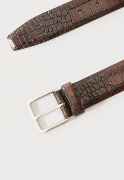Ceinture en cuir marron avec motif crocodile et boucle rectangulaire argentée sur fond clair et uni.