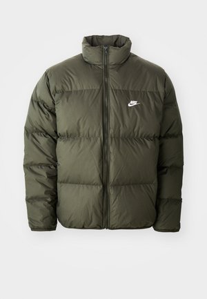 Jacket puffer verde măsliniu cu guler înalt, fermoar frontal și model de cusături orizontale. Dispune de un logo alb Nike pe pieptul stâng.