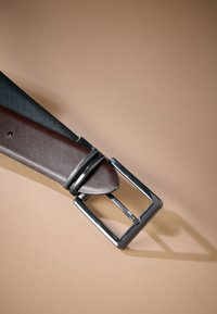 Brown leather belt with a textured black section; features a rectangular silver metal buckle and two silver accent rings.