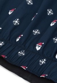 Granatowa tkanina z białymi płatkami śniegu i twarzami Świętego Mikołaja w czerwonych czapkach; elastyczny, falbaniasty dół, gładka tekstura i lekka konstrukcja.