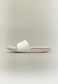 Λευκή σανδάλι με υφή στην σόλα και φαρδιά λουρί, φωτογραφημένη από το πλάι σε ουδέτερο φόντο.