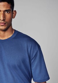 Navyblå t-shirt lavet af blødt bomuld, med rund hals, korte ærmer og en afslappet pasform uden synlige logoer eller mønstre.