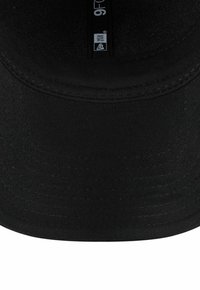 Gorra de béisbol negra con visera plana, hecha de tela texturizada. Presenta un logo bordado y una correa ajustable en la parte posterior.