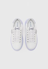 Witte sneakers met een gladleren bovenwerk, lila accenten, regenboogveters en een logo nabij de tong. Rondneus en een plat zoolontwerp.