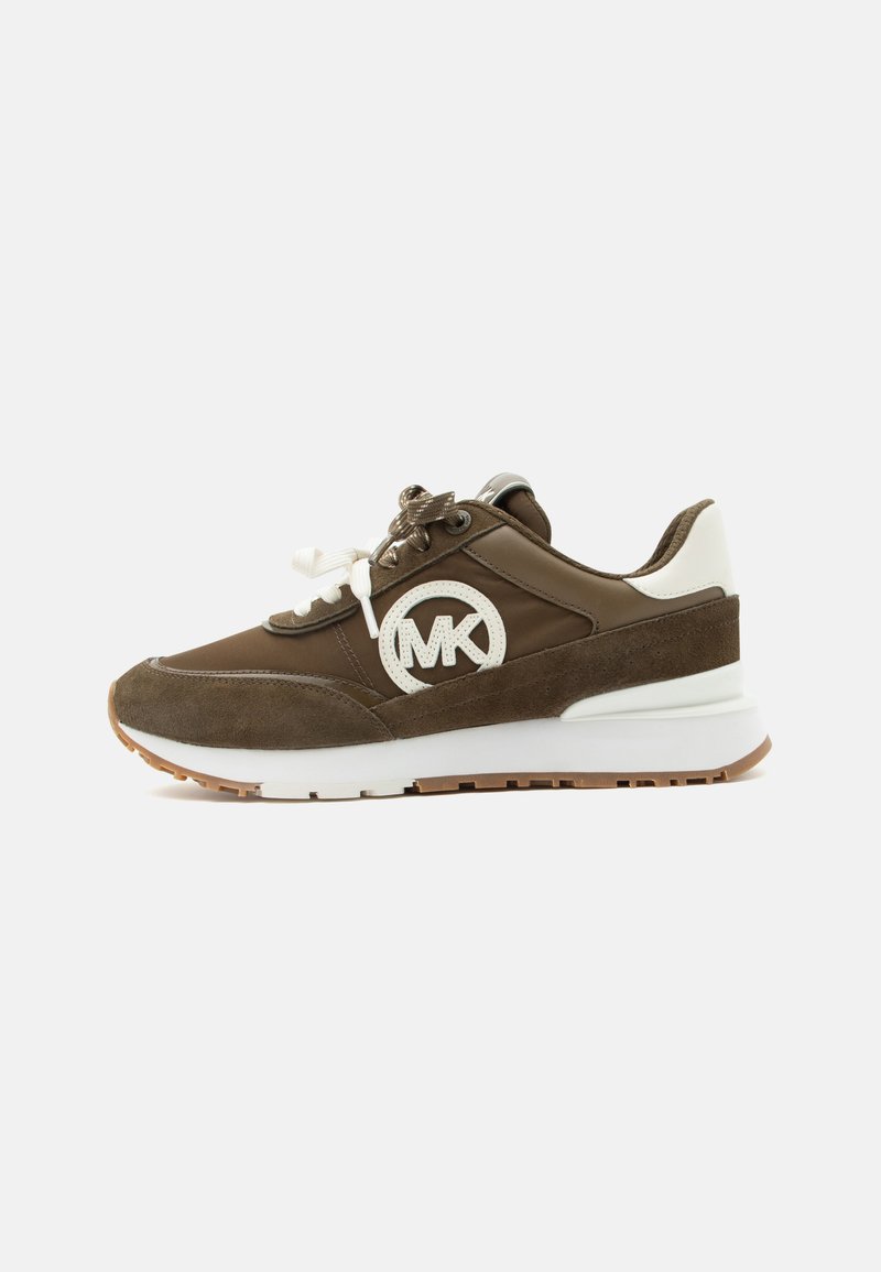 Baskets marron et blanches avec détails en suède, lacets blancs, semelle épaisse et logo circulaire "MK" sur le côté, présentées sur fond blanc.