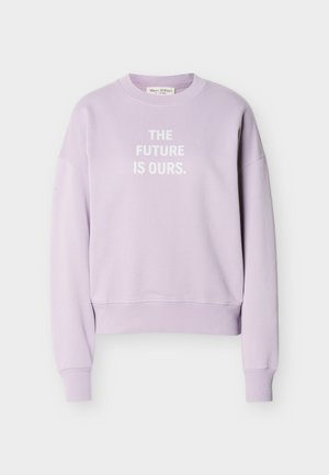 Lilla hettegenser med lange ermer og hvit tekst midt på foran som sier "FREMTIDEN ER VÅR."