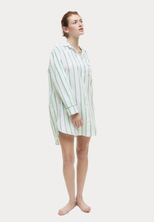 Camisa blanca de botones con rayas verticales verdes, de mangas largas, con cuello y un corte holgado. La camisa llega hasta la mitad del muslo.
