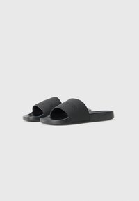 Black slide sandals with an open toe design, made from smooth rubber material, featuring subtle embossed branding on the strap.