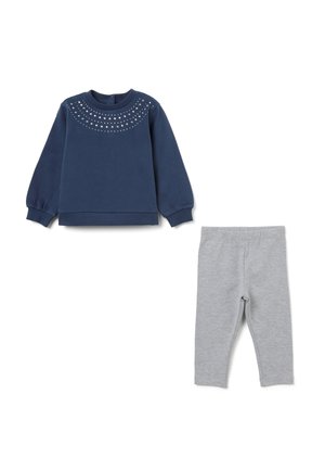 Sweat-shirt marine à manches bouffantes, encolure ornée, et leggings gris. Les deux sont fabriqués dans un tissu doux et extensible, idéal pour le confort.