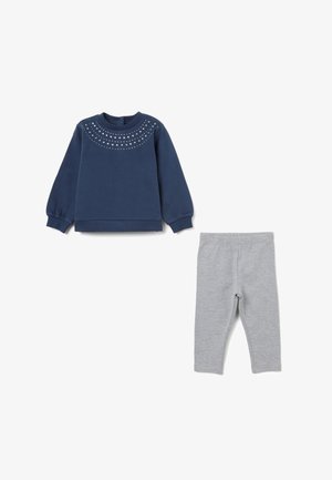 Sudadera azul marino con mangas abullonadas, escote adornado y leggings grises. Ambos hechos de una tela suave y elástica adecuada para la comodidad.