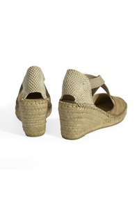 Beige Keilsandaletten mit geflochtener Oberseite aus Stoff, elastischem Knöchelriemen und mit Jute umwickelten Absätzen, mit einem offenen Rückendesign.