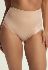 Bielizna w kolorze nude o wysokim stanie, wykonana z gładkiego, elastycznego materiału, z bezszwowym wykończeniem i miękkim paskiem w talii dla komfortu i zakrycia.