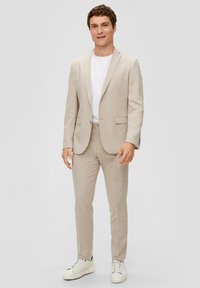 Licht beige pak met een geruit patroon, gemaakt van textuurstof. Gecombineerd met een wit t-shirt en witte sneakers. Perfecte pasvorm.
