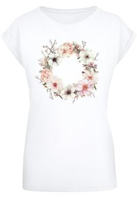 White short-sleeve t-shirt featuring a floral wreath design with pink and white flowers and green leaves at the center.
