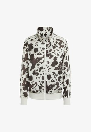 Witte jas met een zwart en bruin koeienprint. Heeft een hoge kraag, rits aan de voorkant en gestreepte accenten op de mouwen. Soepele, lichte stof.