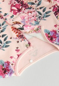 Body a fiori in morbido cotone rosa, con fiori multicolori, chiusure a scatto e un punto testurizzato lungo i bordi.