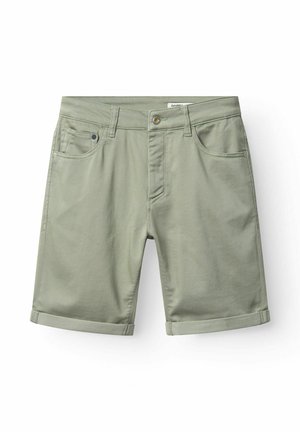 Šviesiai žali medvilniniai šortai su susuktais rankogaliais, priekinė sagutė, užtrauktukas, diržo kilpos ir penkių kišenių dizainas, pateikti ant balto fono.
