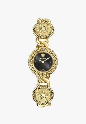 Reloj en tono dorado con diseño de eslabones. La esfera negra presenta una textura acanalada y acentos dorados. Un patrón de llave griega rodea la esfera.