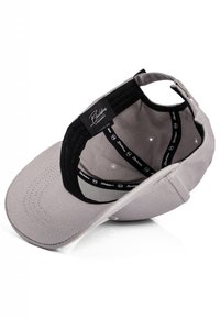 Gray baseball cap featuring a curved brim, black interior lining, and logo detail. Material appears to be cotton with a smooth texture.