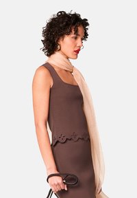 Bruine mouwloze top met bloemenborduurwerk langs de zoom, gecombineerd met een lichtbeige sjaal. Glad textuur, slanke pasvorm, elegant ontwerp.