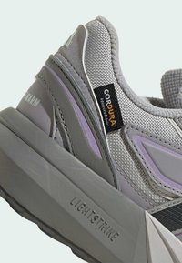 Gray sneaker featuring a mesh upper with purple accents, a textured rubber sole, and a visible "Cordura" label. Lightweight design with a thick sole.