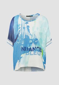 Kurzärmliges, cropped Top in Hellblau und Weiß, mit einem Aquarell-Palmenbaum-Design und dem Text "NUANCE BLEU" in fettem Marineblau.