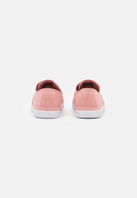Sneakers in tela rosa con un design a profilo basso, suola in gomma bianca e senza loghi o motivi visibili nella vista posteriore.
