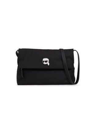 Sac à bandoulière noir en nylon avec un design rabattu, présentant un accent en métal argenté représentant un personnage. Bretelle ajustable incluse.