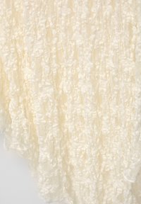 Kantstof in een zachte crèmekleur met gestructureerde, gelaagde patronen en een delicate, luchtige uitstraling. Geschikt voor diverse kleding.