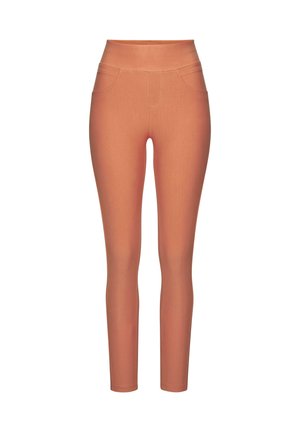 Close-up of person wearing high-waisted, coral-colored pants with back pockets and a hand resting on the hip.