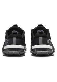 Scarpe da ginnastica nere con tomaia in rete, accenti grigi lucidi e suole nere testurizzate, dotate di una linguetta e dettagli del brand sul tallone.