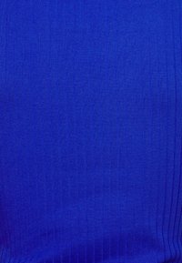 Žebrovaná tkanina v živé královské modré barvě, které se vyznačuje hladkým povrchem s vertikálními pruhy.