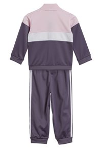 Tuta in poliestere viola e rosa con strisce bianche, caratterizzata da un colletto alto e polsini a costine. Tessuto morbido, design atletico.