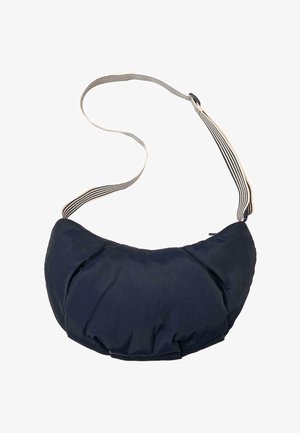 Sac à bandoulière matelassé bleu marine en forme de croissant avec sangle beige ajustable ornée de rayures noires et fermeture à glissière.