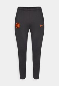 Melni sporta bikses ar elastīgu jostu, sašaurinātu dizainu, oranžu Nike logo un oranžu apļa emblēmu uz augšstilba. Mīksta, gluda auduma.