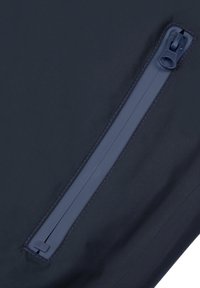 Tejido de color navy con una textura suave presenta una cremallera vertical en color a juego, detallada con costuras en contraste a lo largo de los bordes.