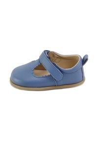 Zapato Mary Jane de cuero azul con recortes en forma de ondas, correa de velcro ajustable y un forro interior suave. Cuenta con una suela flexible color marrón.